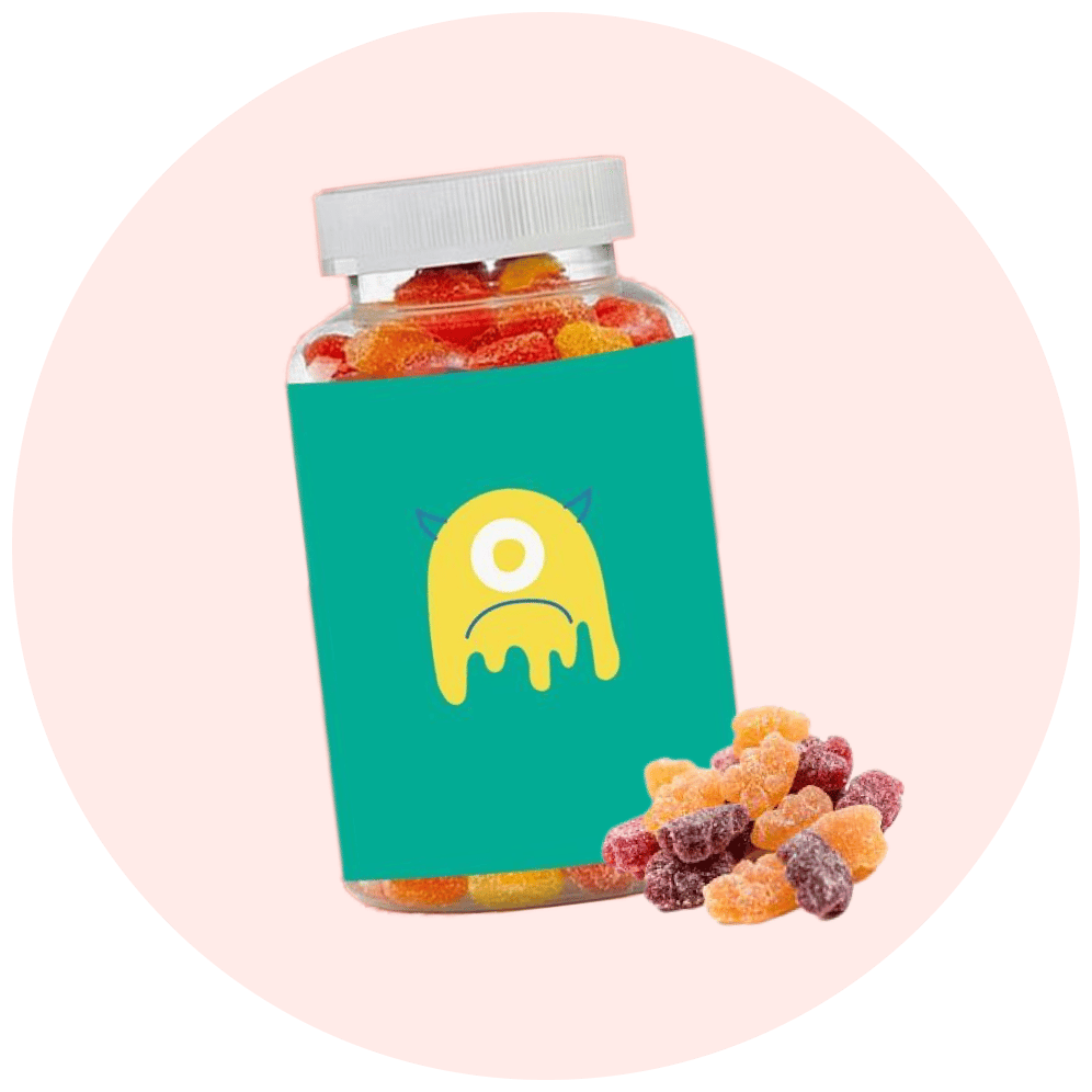 A jar of colorful gummy candies with a playful monster design on the label, surrounded by scattered gummies.