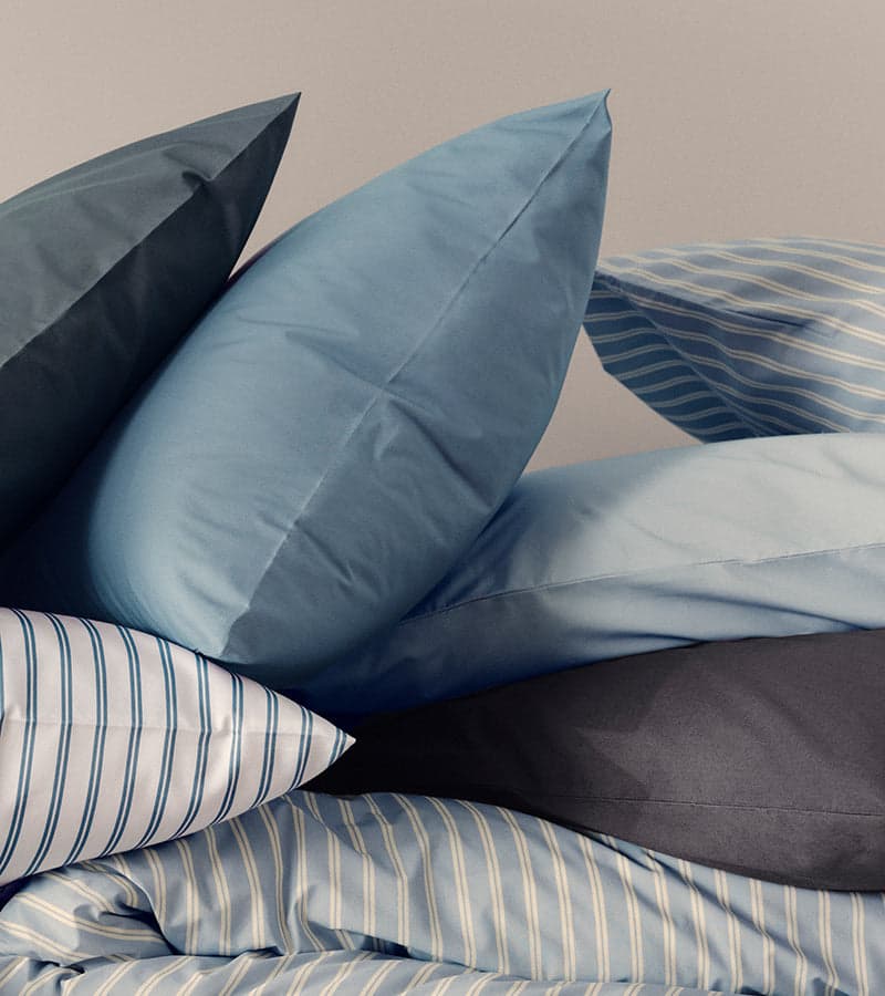 Blue sheets on a made bed