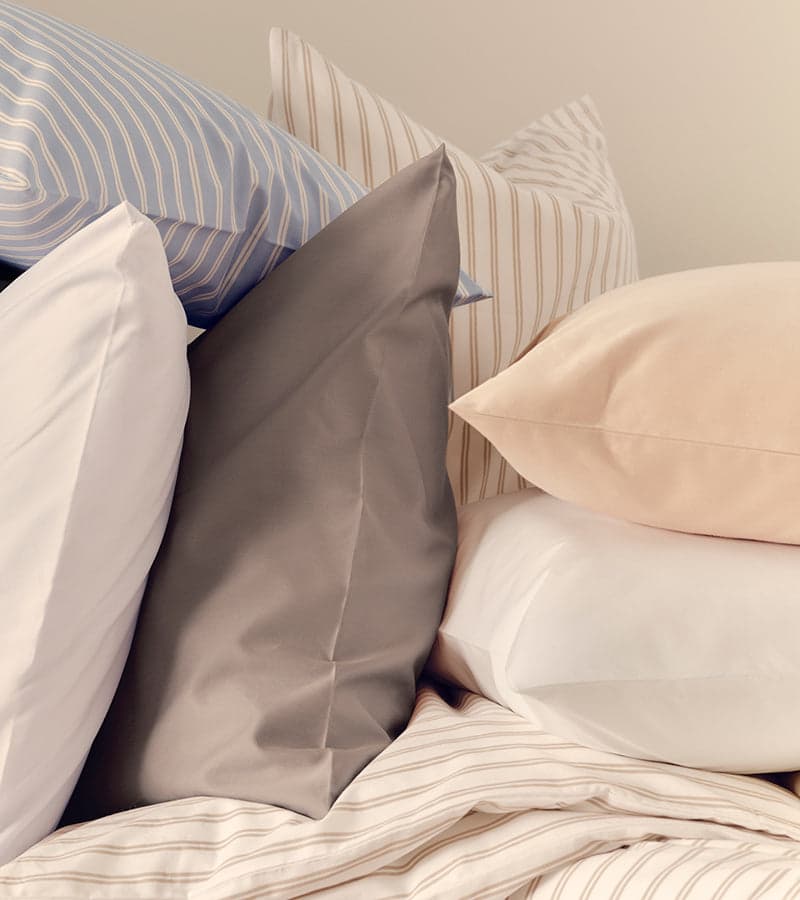 Neutral-toned sheets on a made bed