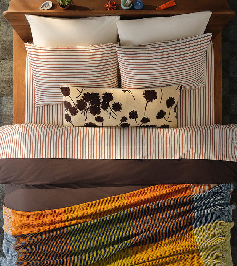 Brown-toned bedding on a made bed