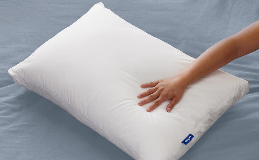 A hand feeling the Casper Original Pillow