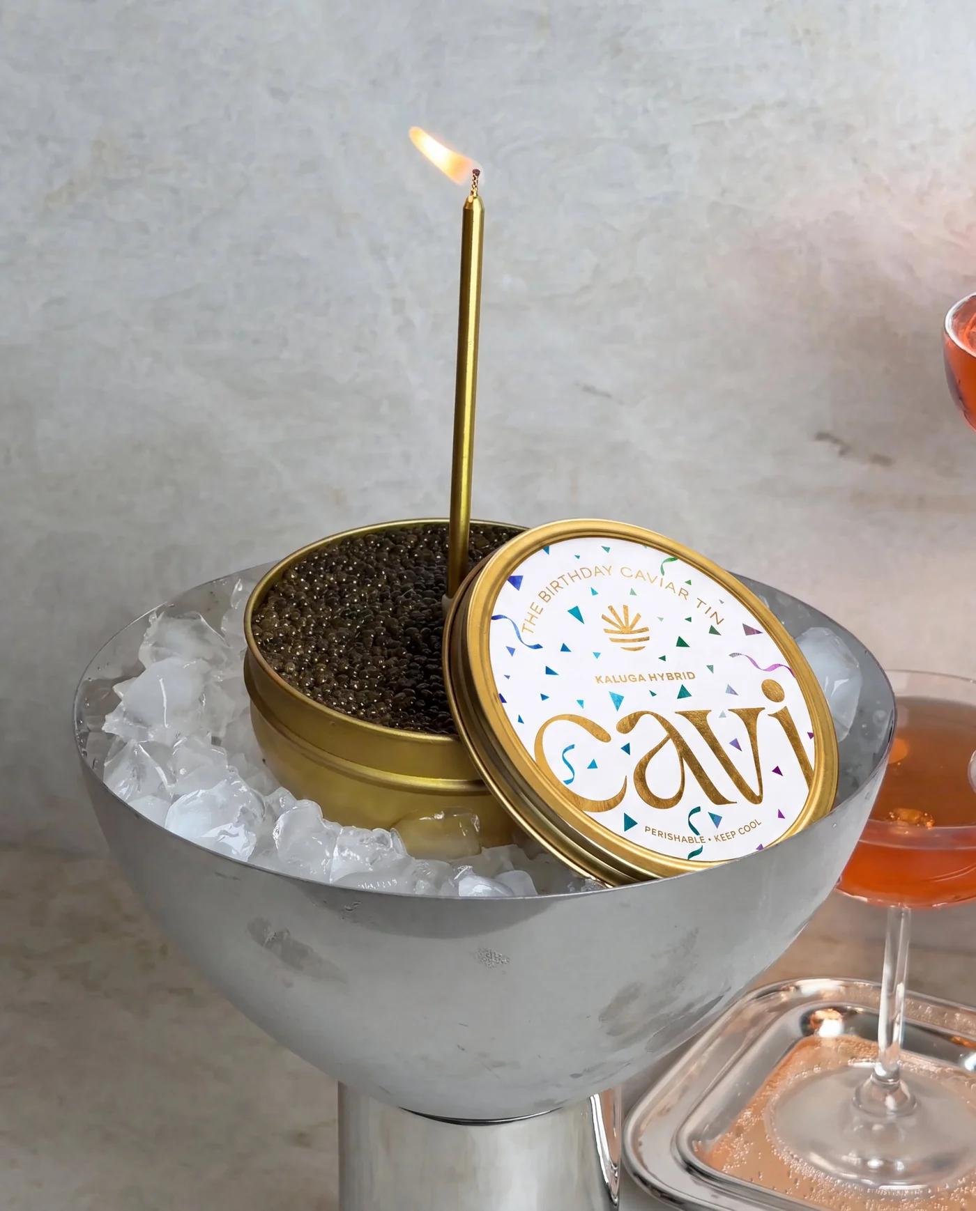 A candle lit in a tin of CAVI caviar