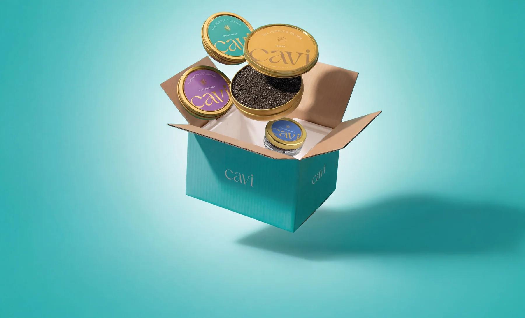 A CAVI shipping box packed with caviar tins, lids popping out