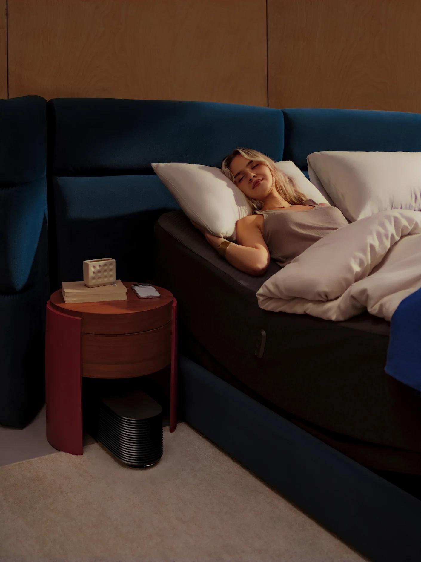 A couple asleep in a dark bedroom, one of them on their back