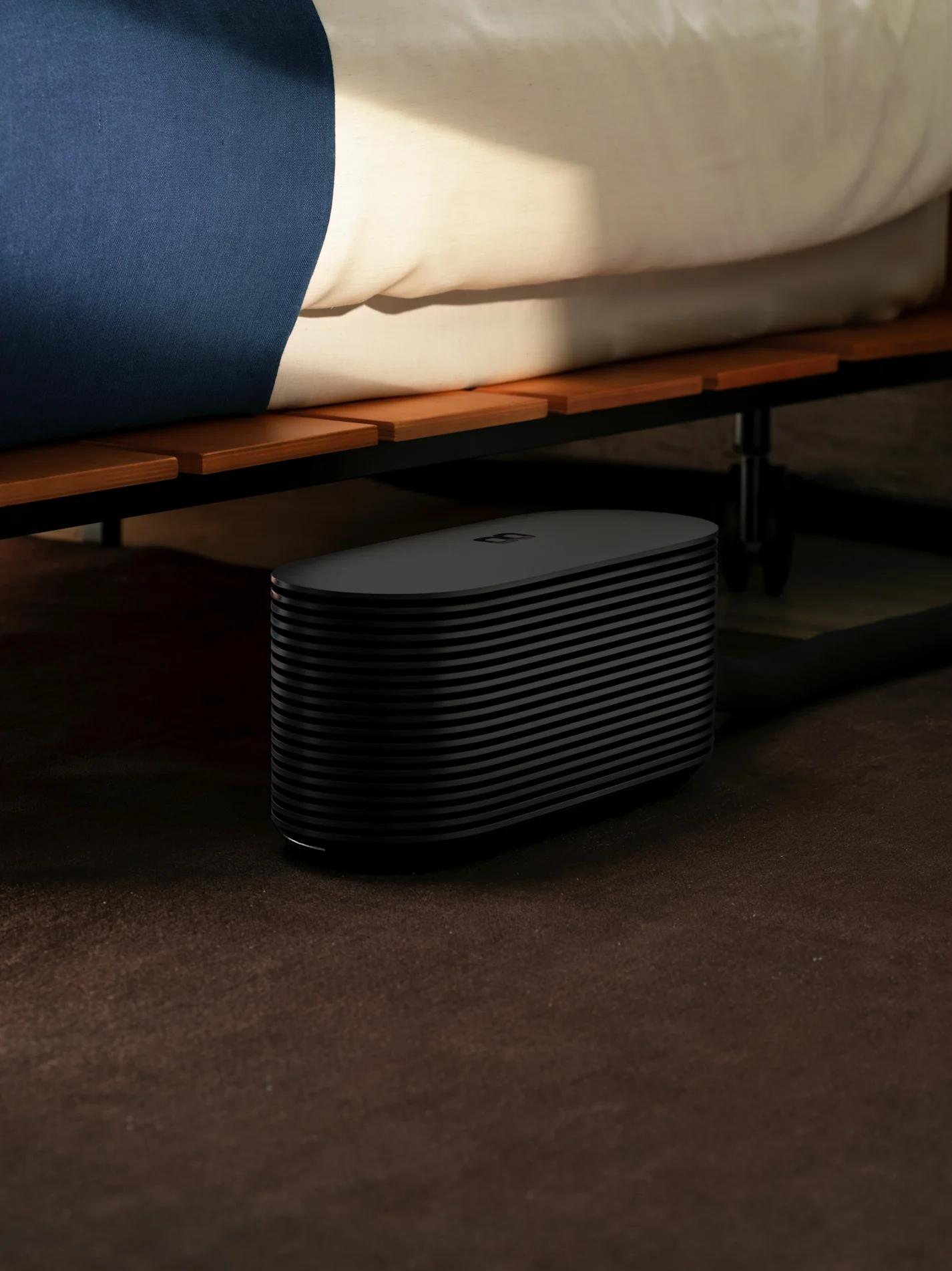 The Pod Hub on the floor beside a bed