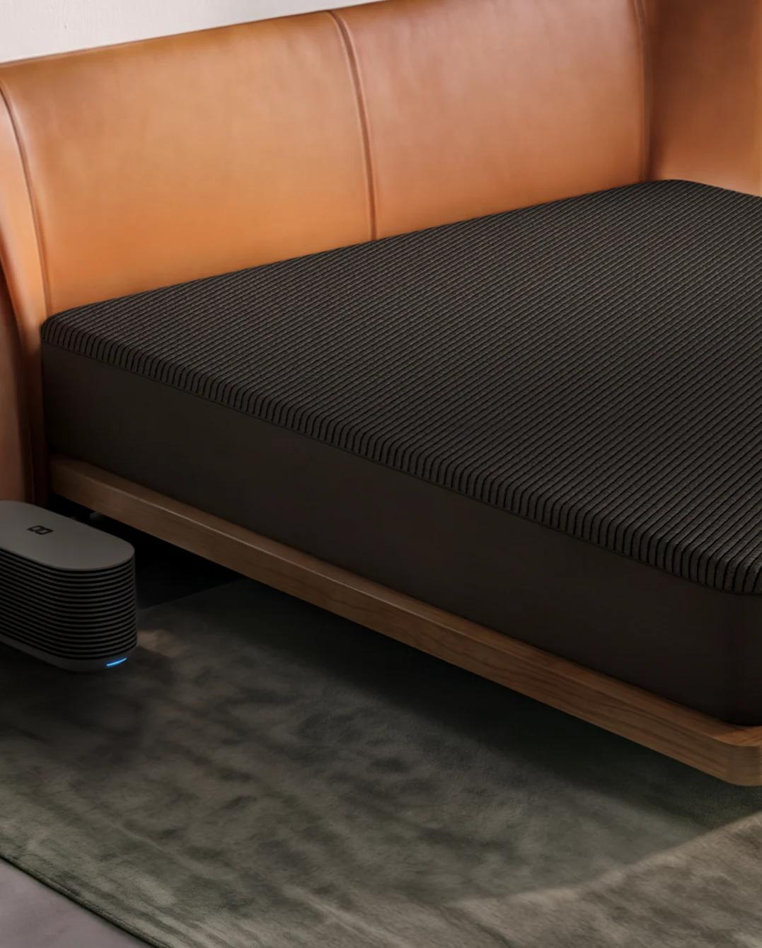 A Pod 6 Cover on a king bed in a bright bedroom, with the Hub on the floor beside it