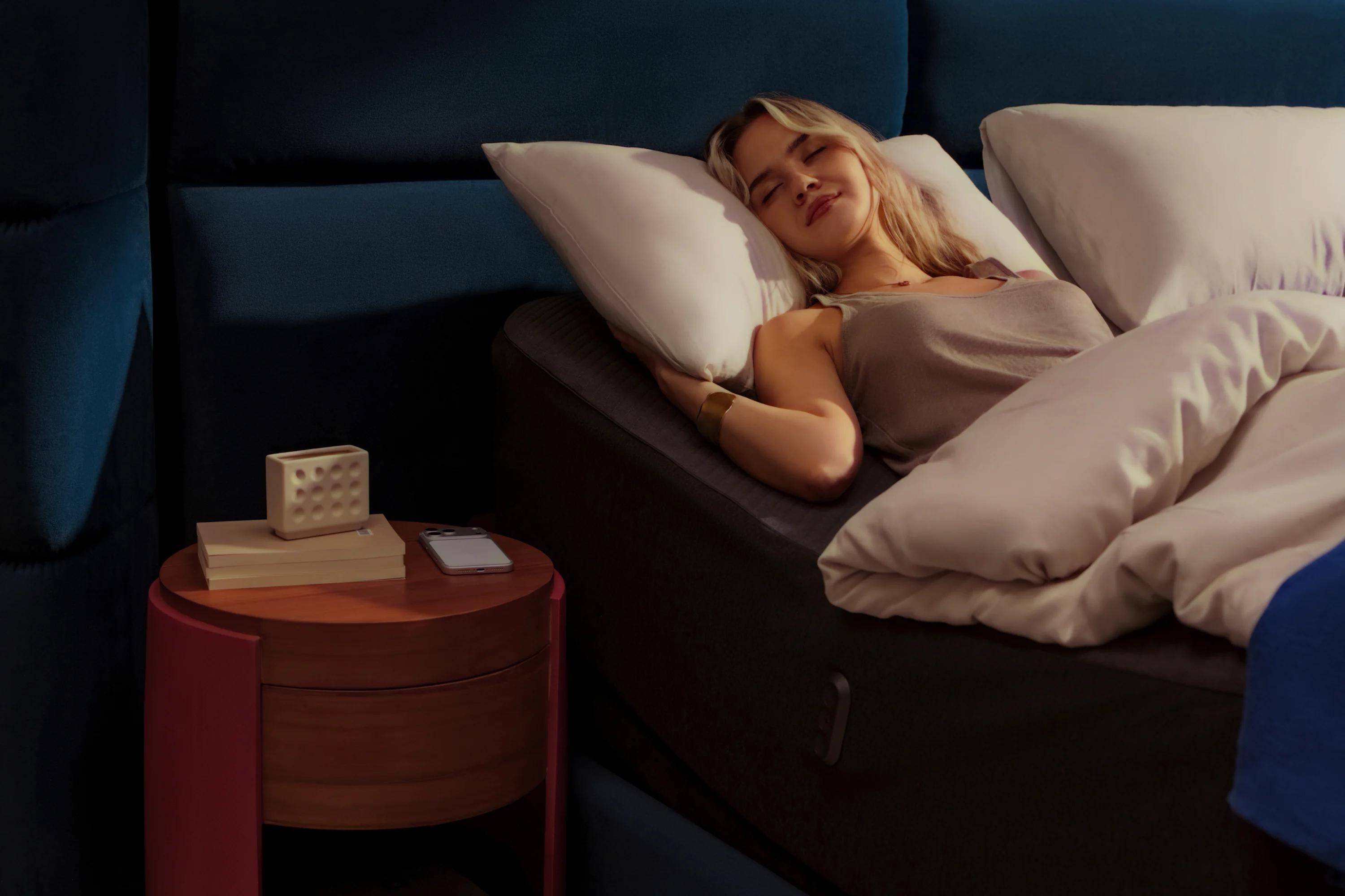 A woman lying in a raised bed at night, reducing back pressure.