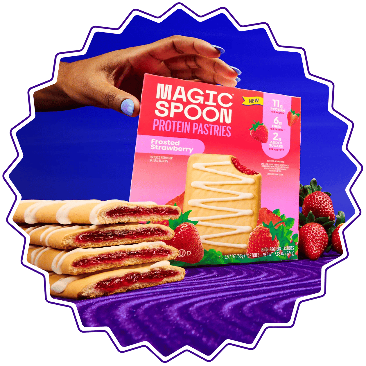 Hand holding a box of Magic Spoon Frosted Strawberry Protein Pastries above stacked pastries and strawberries