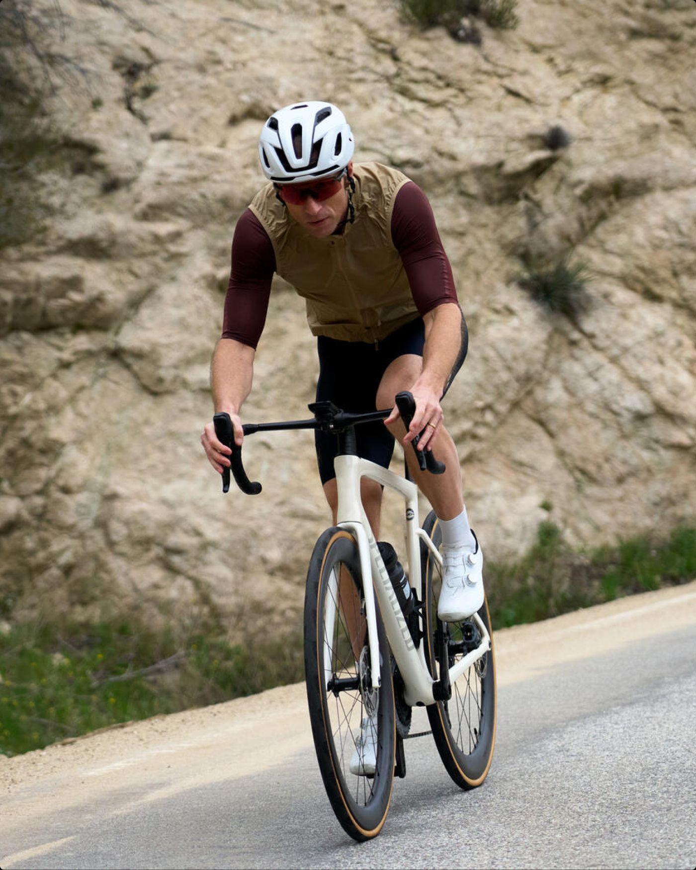 Cyclist riding a road bike along a rocky hillside