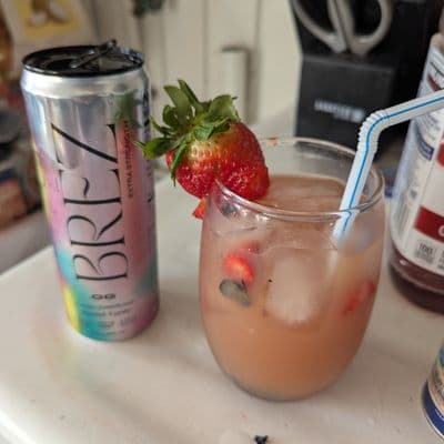 Pink beverage in glass jar with strawberries