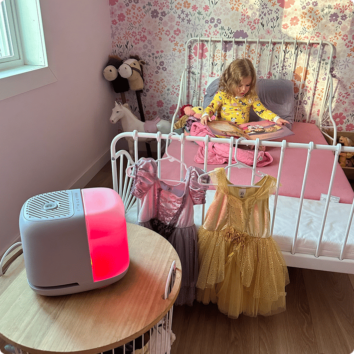 Nursery humidifier glowing red on a bedside table in a kid's room