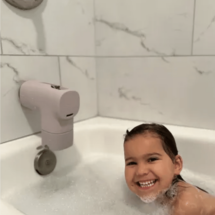 Child smiling in the bath under a Canopy bath tub filter
