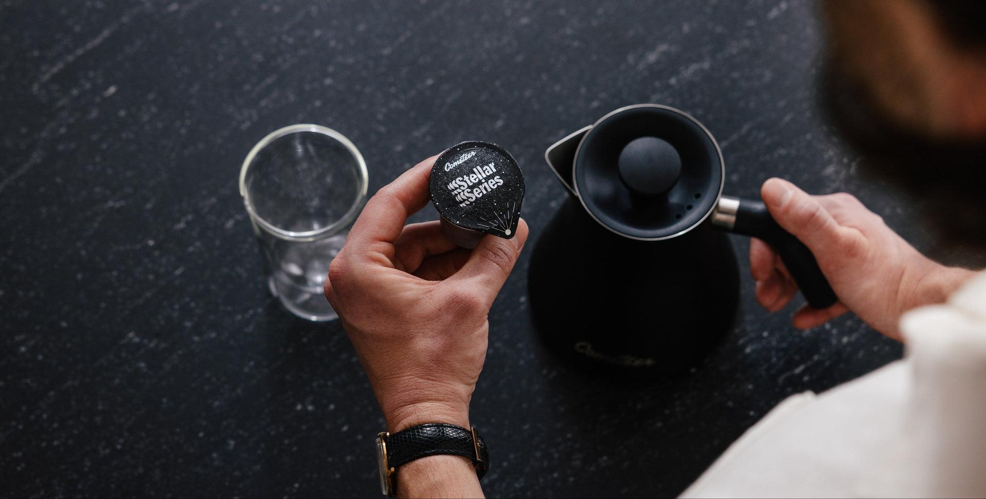 Coffee capsule being opened over a kettle