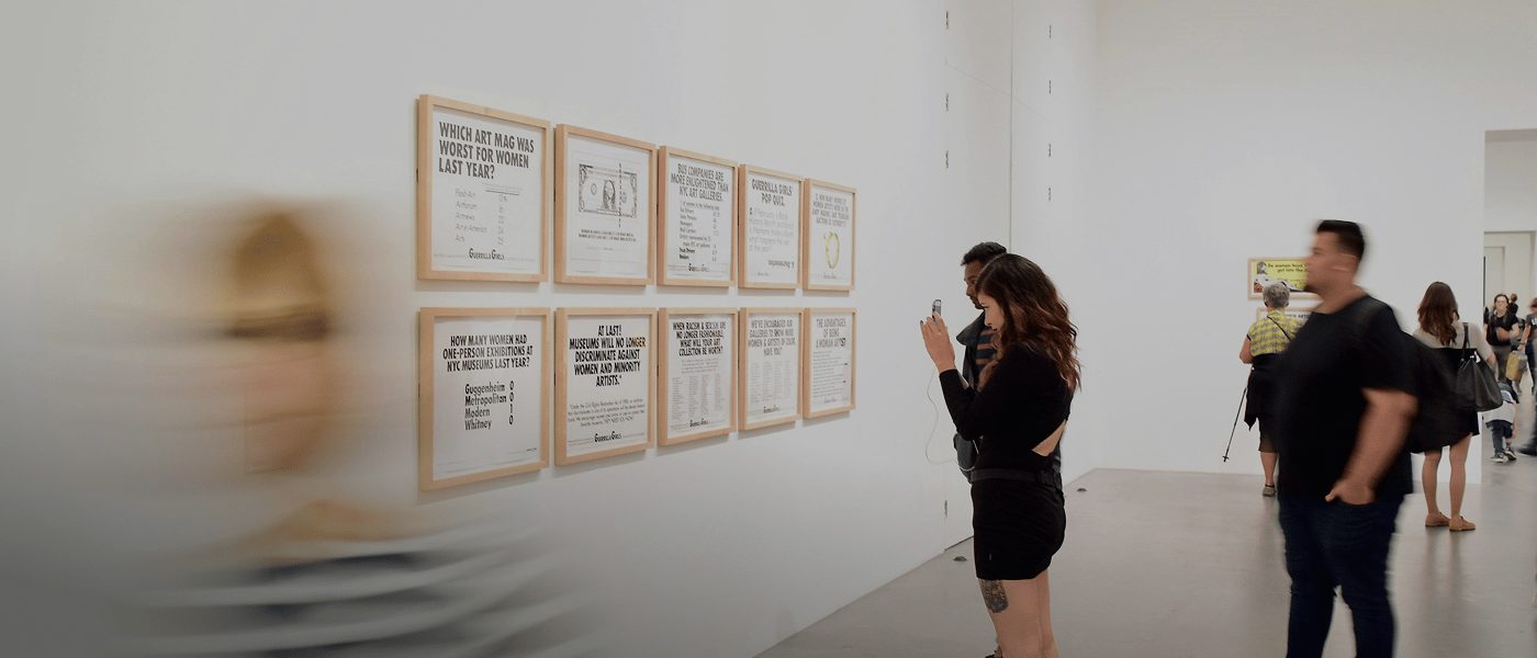 Visitors viewing framed prints inside a gallery