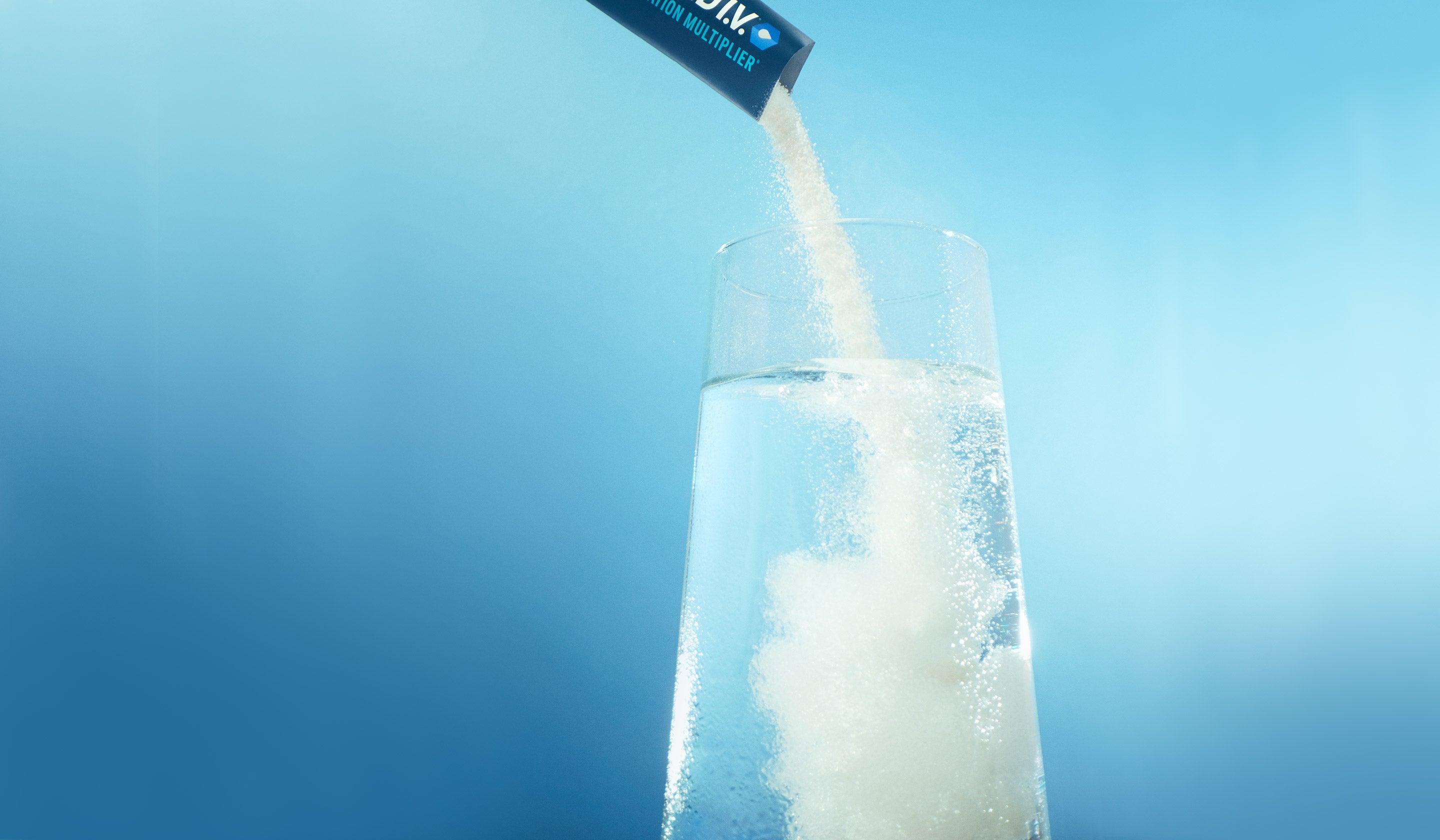 Liquid I.V. Hydration Multiplier powder pouring from a stick packet into a glass of water