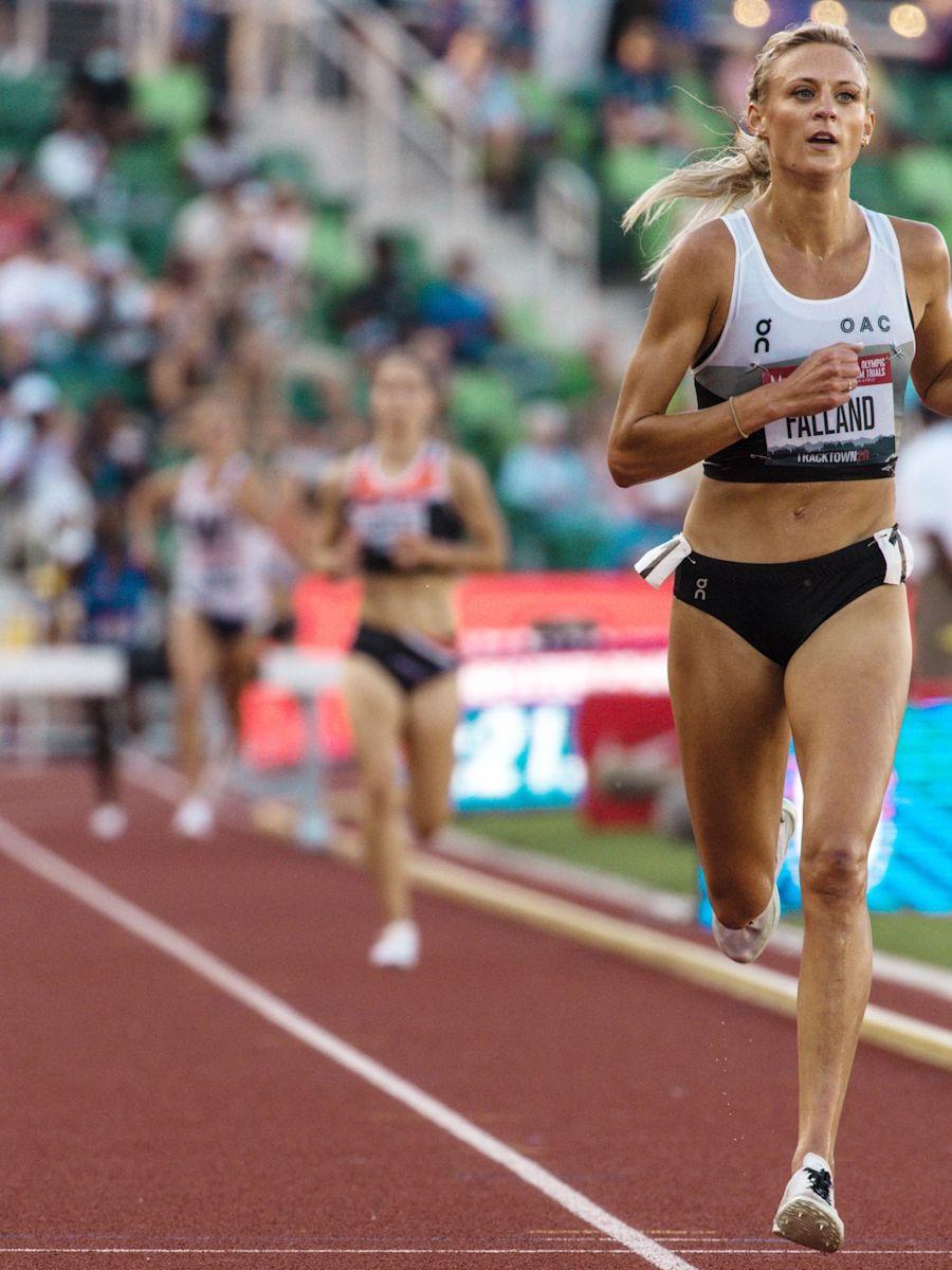 Leah Falland running on track in On gear, as other runners are trailing behind her.