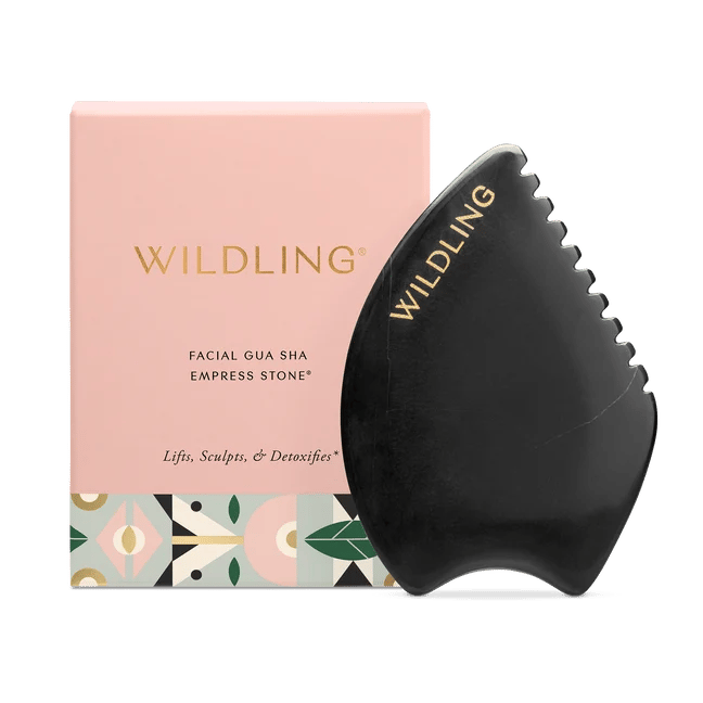 Empress Stone gua sha tool beside its pink Wildling box