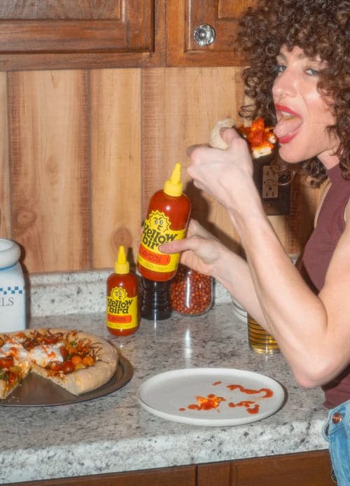 A picture of a Yellowbird hot sauce bottle held in hand