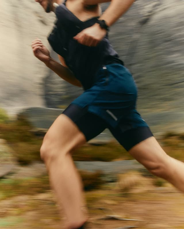 A person in motion, running through a natural outdoor setting.