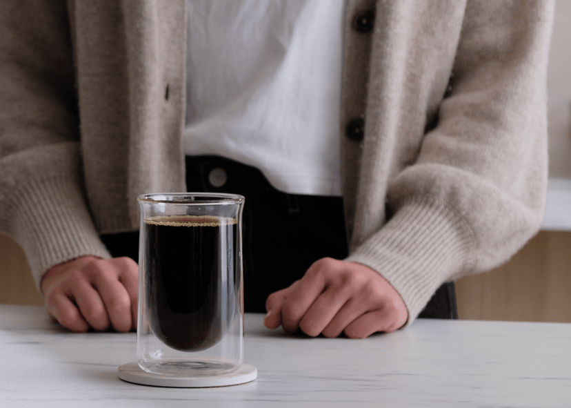 Person holding glass of coffee